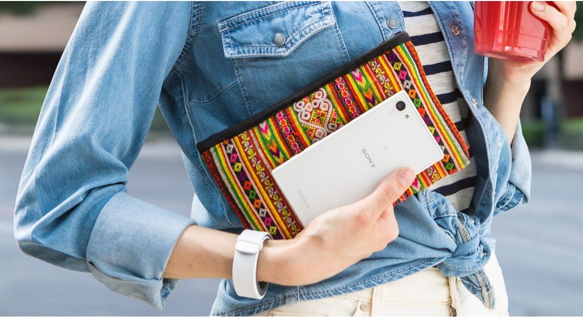 A woman holding a white Xperia Z5 Compact